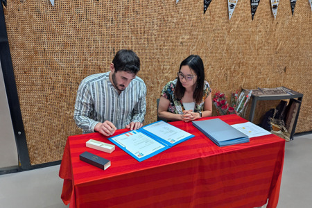 omar afstuderen, diploma ondertekenen aan tafel met docent